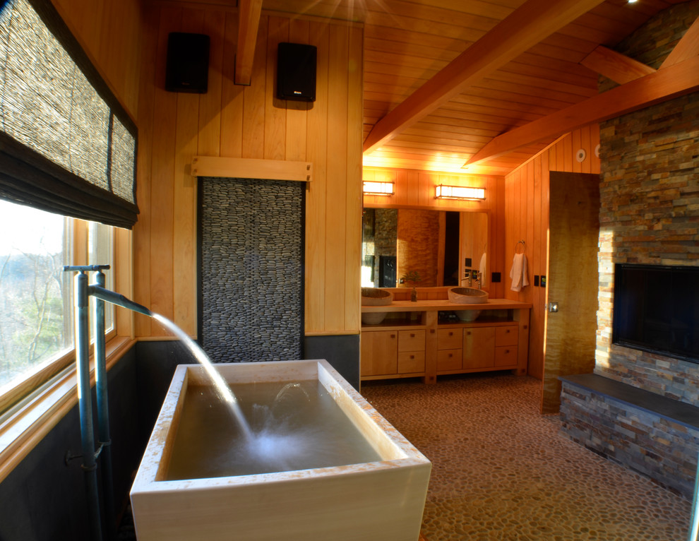 Idéer för stora orientaliska en-suite badrum, med släta luckor, skåp i ljust trä, ett fristående badkar, flerfärgad kakel, stenkakel, bruna väggar, klinkergolv i småsten, ett nedsänkt handfat, träbänkskiva och flerfärgat golv