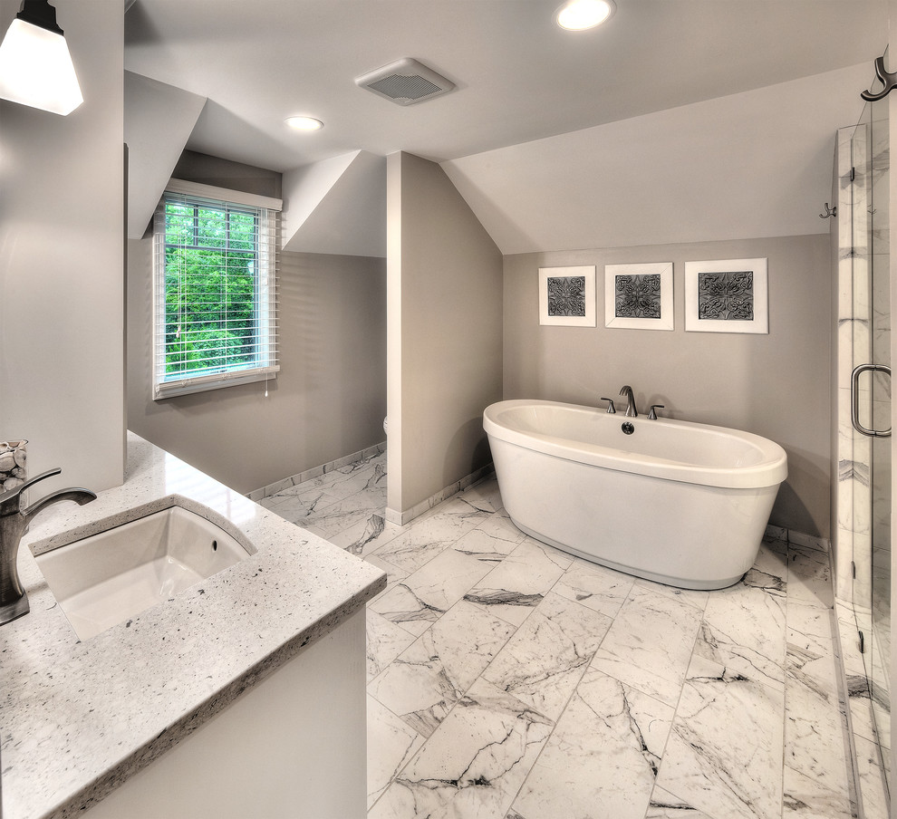 Exempel på ett stort klassiskt en-suite badrum, med luckor med infälld panel, vita skåp, ett fristående badkar, en öppen dusch, en toalettstol med separat cisternkåpa, vit kakel, porslinskakel, grå väggar, klinkergolv i porslin, ett undermonterad handfat och bänkskiva i kvarts