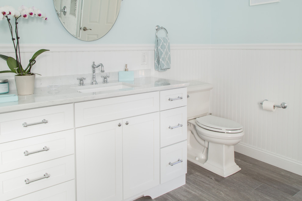 Klassisk inredning av ett stort en-suite badrum, med skåp i shakerstil, vita skåp, en toalettstol med separat cisternkåpa, grå kakel, blå väggar, klinkergolv i porslin, ett undermonterad handfat, marmorbänkskiva och porslinskakel