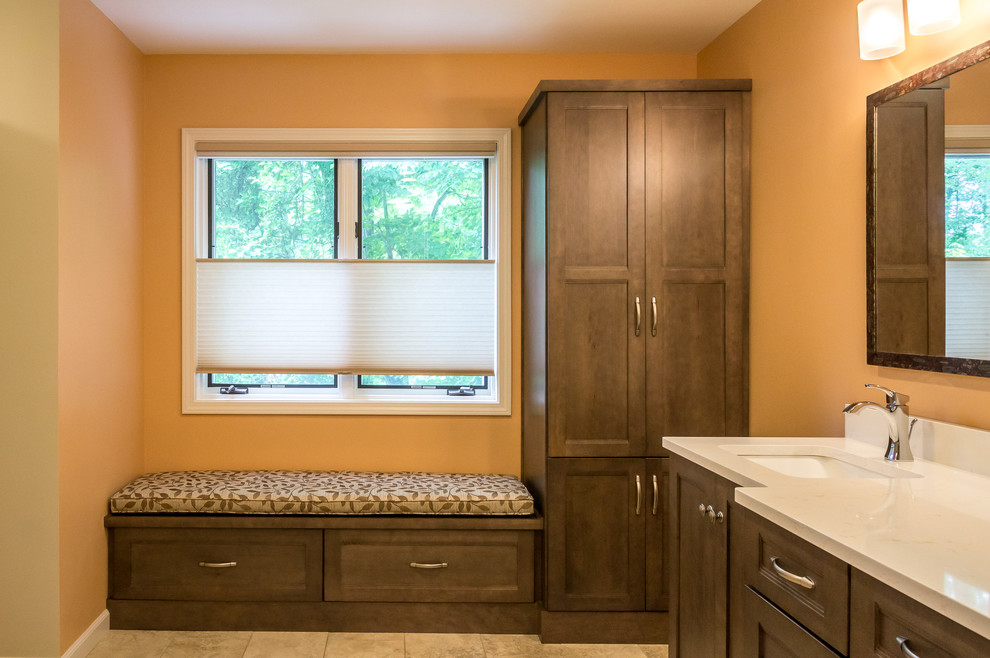 Inspiration for a mid-sized craftsman master beige tile and ceramic tile ceramic tile and brown floor alcove shower remodel in Other with shaker cabinets, medium tone wood cabinets, orange walls, a wall-mount sink, quartz countertops, a hinged shower door and white countertops