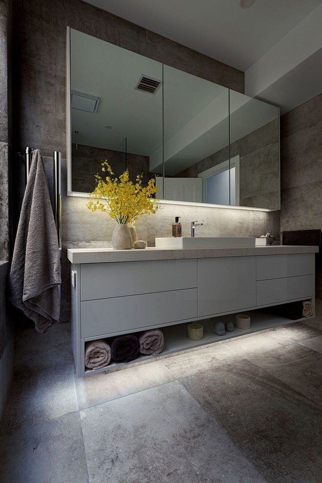 Cette image montre une salle de bain design avec des portes de placard blanches, un carrelage marron, des carreaux de porcelaine, un sol en carrelage de porcelaine, un plan de toilette en surface solide, un sol marron et un plan de toilette beige.