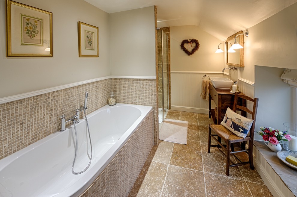 Photo of a large classic family bathroom in Manchester with a built-in bath, an alcove shower, beige tiles, stone tiles and limestone flooring.