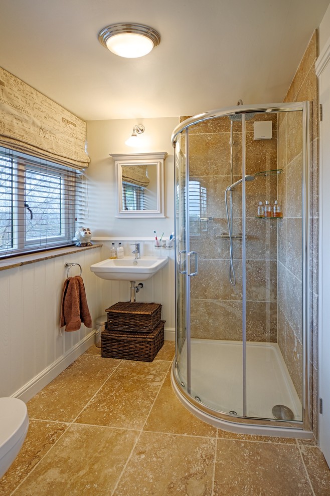 Foto di una piccola stanza da bagno padronale chic con lavabo sospeso, doccia ad angolo, WC monopezzo, piastrelle beige, piastrelle in pietra, pareti bianche e pavimento in pietra calcarea