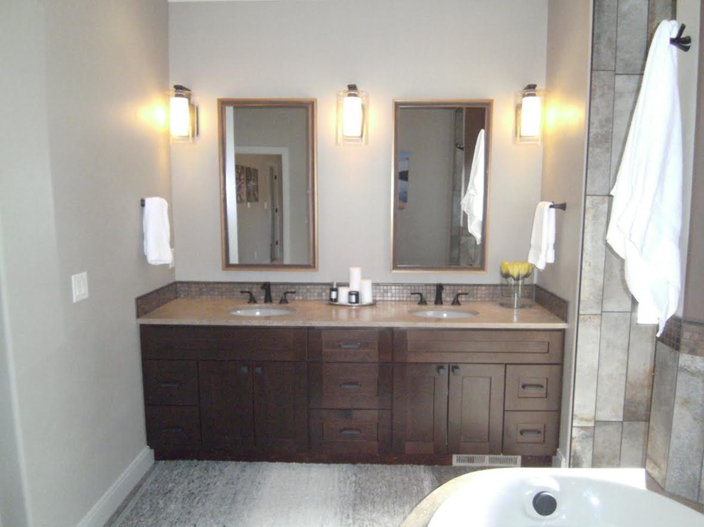 Esempio di una stanza da bagno padronale tradizionale di medie dimensioni con ante in stile shaker, ante in legno bruno, vasca ad angolo, doccia alcova, piastrelle beige, pareti beige, lavabo sottopiano e top in superficie solida