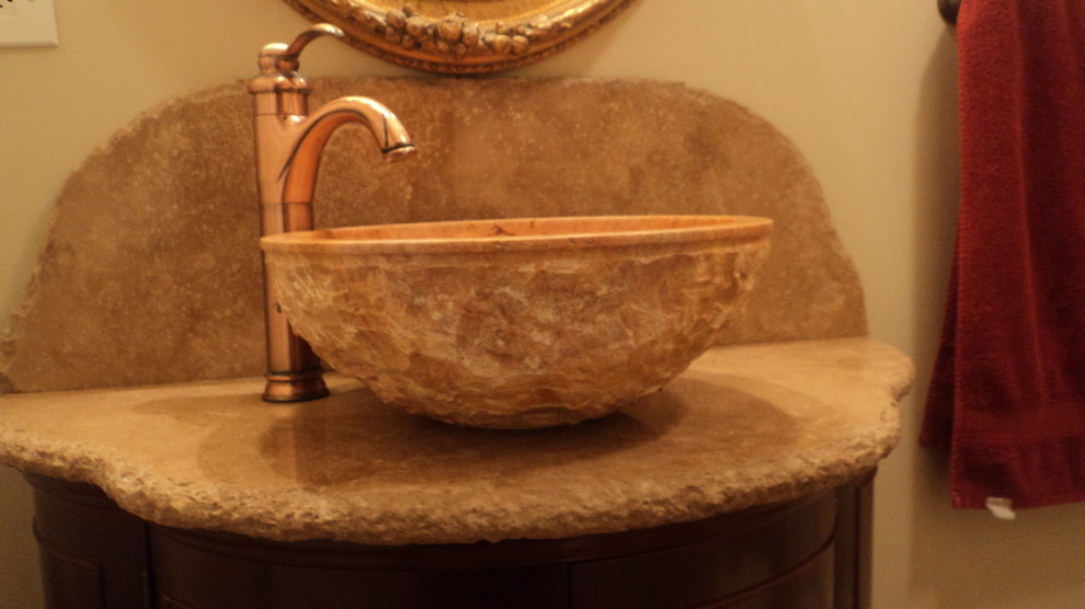 Immagine di una piccola stanza da bagno con doccia mediterranea con ante a filo, ante in legno bruno, piastrelle beige, lastra di pietra, pareti beige, lavabo a bacinella e top in cemento