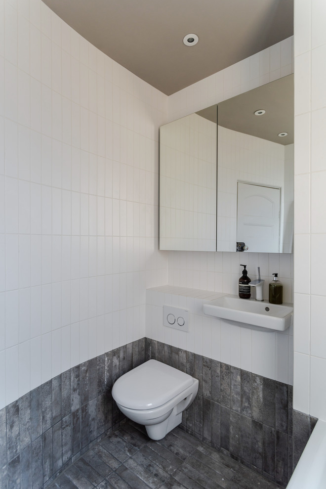 На фото: ванная комната в современном стиле с инсталляцией, серой плиткой, белой плиткой, подвесной раковиной и серым полом