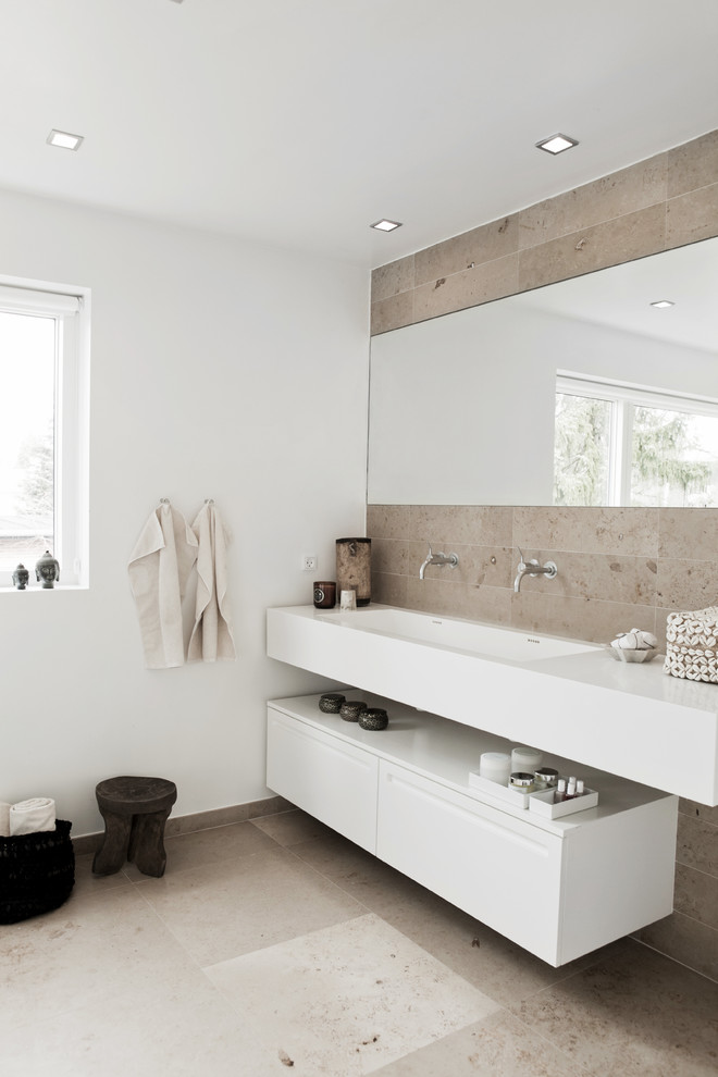 Inspiration for a contemporary beige tile and stone tile bathroom remodel in West Midlands with an integrated sink, flat-panel cabinets, white cabinets and white walls