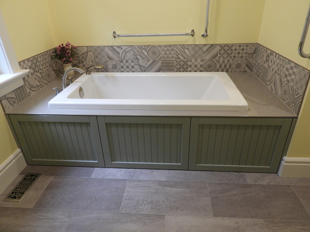 Inspiration for a small country 3/4 gray tile and ceramic tile vinyl floor and gray floor drop-in bathtub remodel in Toronto with beaded inset cabinets, green cabinets, a two-piece toilet, yellow walls, a drop-in sink, laminate countertops and gray countertops