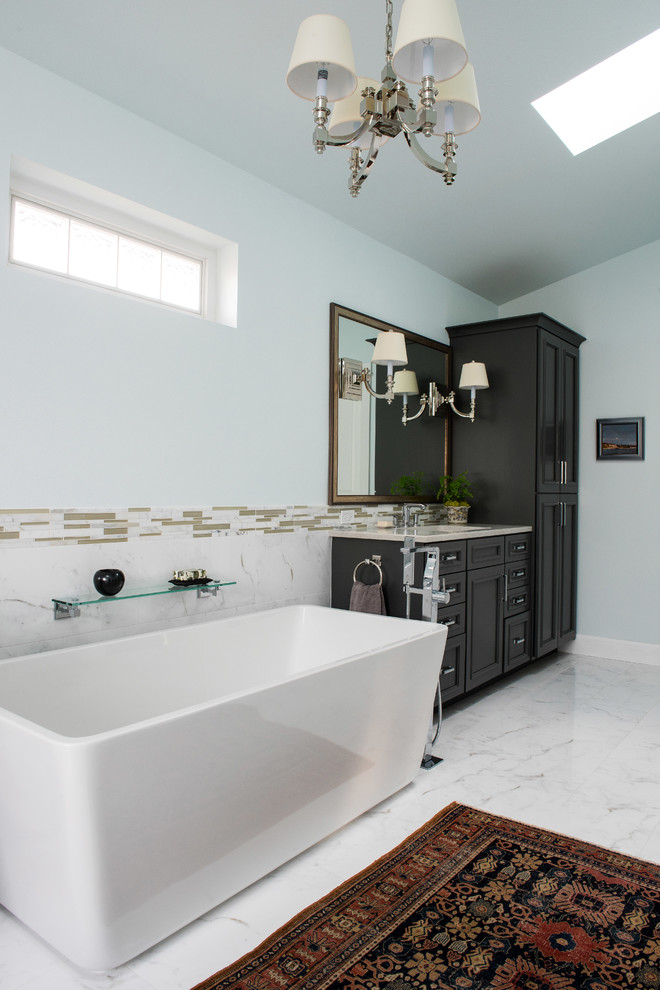 This is an example of a large classic ensuite bathroom in Other with recessed-panel cabinets, black cabinets, a freestanding bath, an alcove shower, blue walls, marble flooring, white floors, grey tiles, white tiles, stone tiles, a submerged sink, engineered stone worktops and a hinged door.