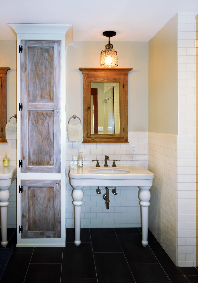 Exempel på ett mellanstort amerikanskt en-suite badrum, med tunnelbanekakel, ett piedestal handfat, möbel-liknande, skåp i slitet trä, en toalettstol med hel cisternkåpa, röd kakel, klinkergolv i porslin och grått golv