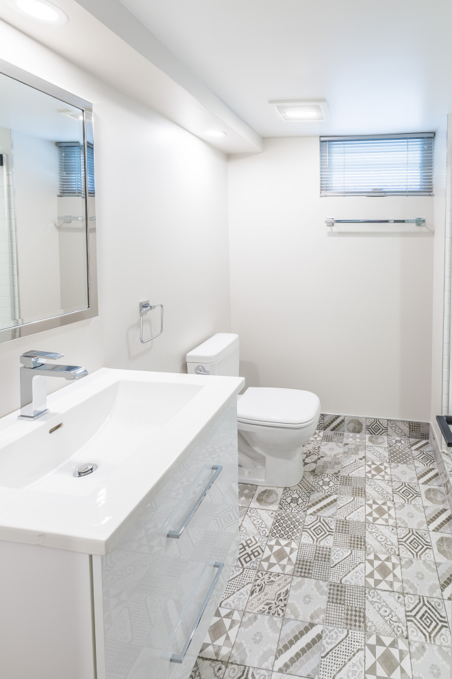 Modern inredning av ett mellanstort vit vitt badrum med dusch, med släta luckor, vita skåp, en öppen dusch, vit kakel, marmorbänkskiva, en toalettstol med hel cisternkåpa, vita väggar, beiget golv och dusch med gångjärnsdörr