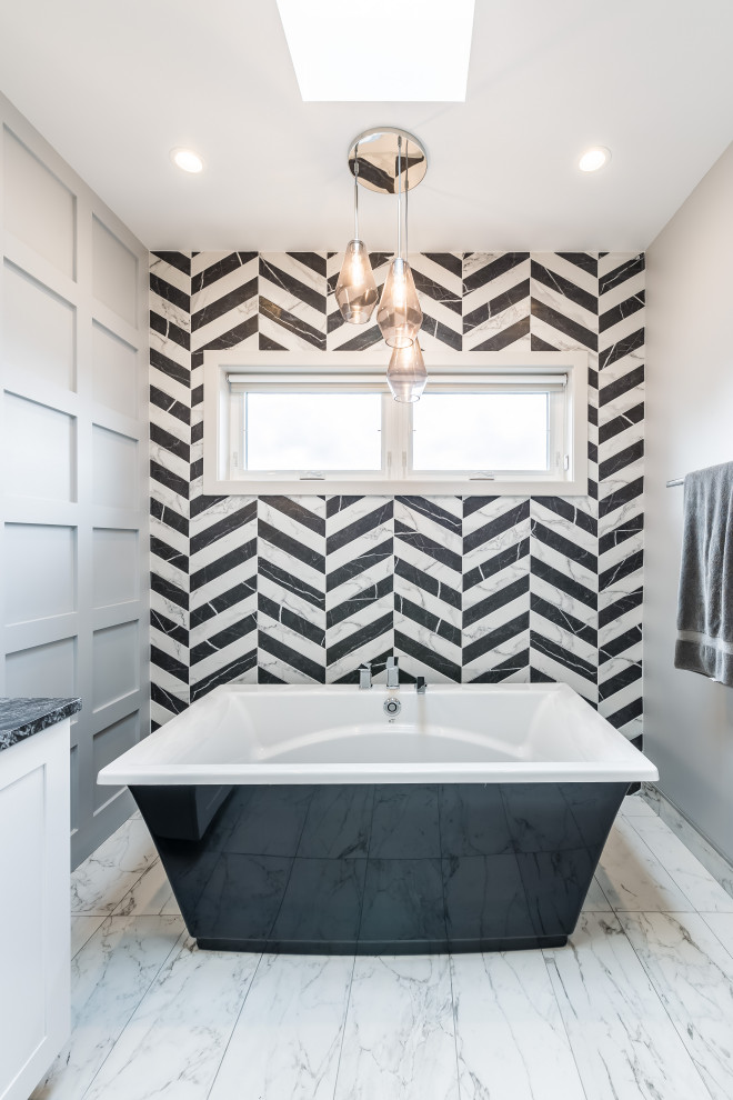 Inspiration for a medium sized classic ensuite bathroom in Chicago with a freestanding bath, a one-piece toilet, black and white tiles, grey walls, marble flooring, a built-in sink, white floors and panelled walls.