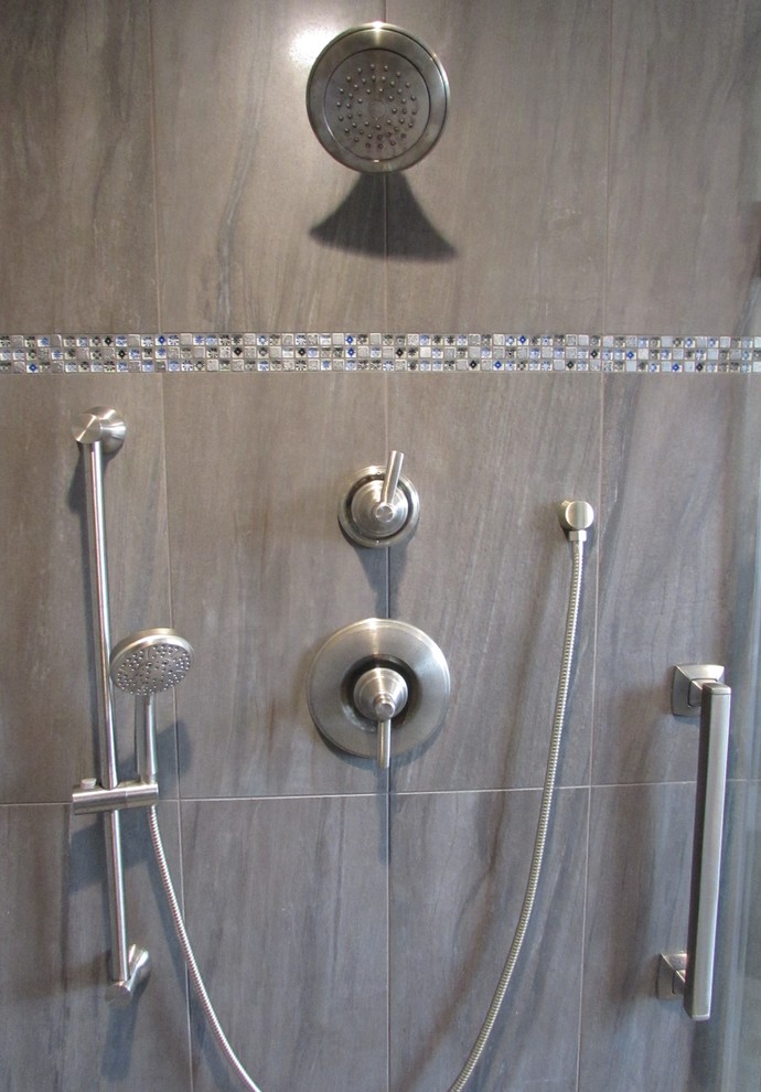 Immagine di una grande stanza da bagno padronale country con ante in legno scuro, piastrelle grigie, piastrelle in ceramica, lavabo sottopiano, top in granito e porta doccia a battente