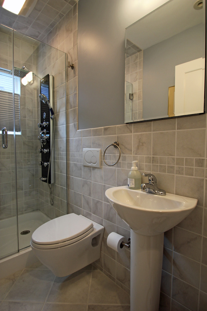 Ejemplo de cuarto de baño clásico con lavabo con pedestal, sanitario de pared, baldosas y/o azulejos de porcelana y suelo de mármol