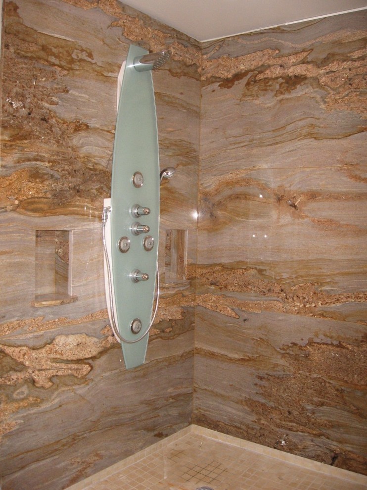 Ispirazione per una stanza da bagno padronale tradizionale di medie dimensioni con ante con bugna sagomata, ante in legno bruno, vasca da incasso, piastrelle marroni, pareti beige e top in granito