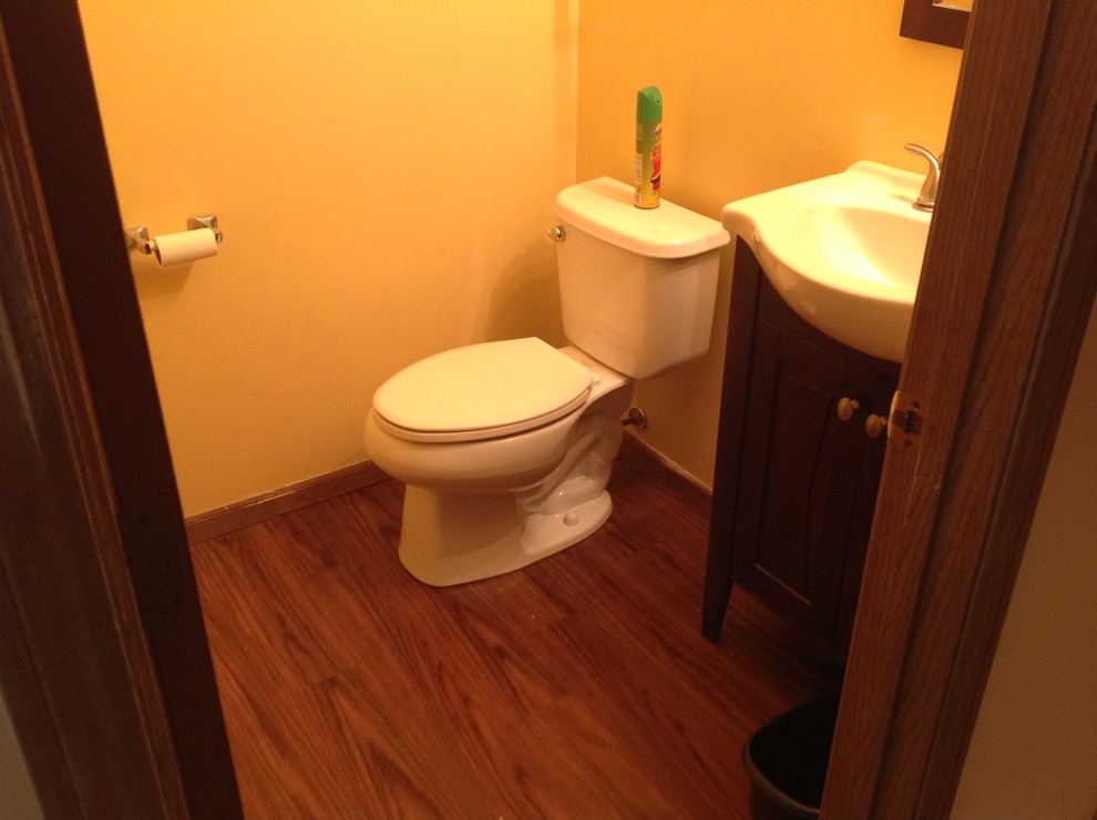 Inspiration för små moderna badrum med dusch, med luckor med upphöjd panel, skåp i mörkt trä, en toalettstol med separat cisternkåpa, gula väggar och mörkt trägolv