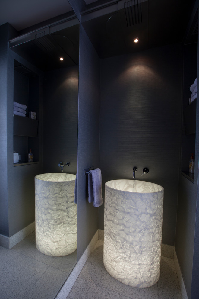 Modern inredning av ett litet badrum med dusch, med öppna hyllor, grå skåp, marmorbänkskiva, grå kakel, stenkakel, grå väggar och betonggolv
