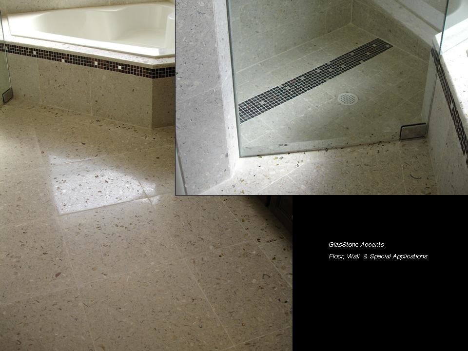 Esempio di una stanza da bagno con doccia tropicale di medie dimensioni con WC monopezzo, piastrelle beige, piastrelle in pietra, pareti beige, pavimento in cemento, lavabo integrato e top piastrellato