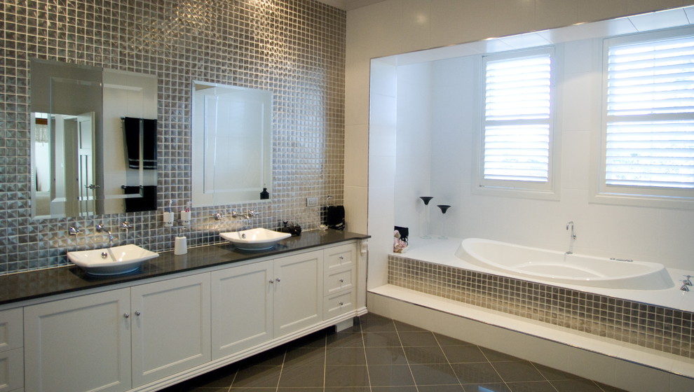 Inredning av ett klassiskt stort en-suite badrum, med ett avlångt handfat, skåp i shakerstil, vita skåp, bänkskiva i kvarts, ett undermonterat badkar, kakel i metall, vita väggar och klinkergolv i keramik