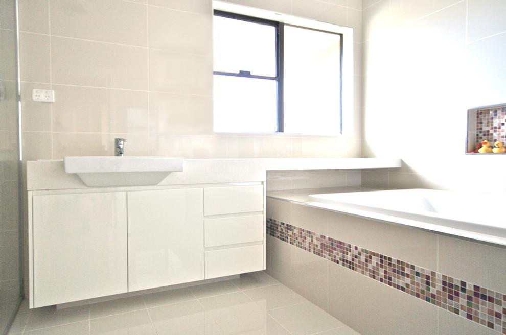 Идея дизайна: главная ванная комната среднего размера в стиле модернизм с плоскими фасадами, белыми фасадами, столешницей из искусственного кварца, накладной ванной, угловым душем, бежевой плиткой, керамической плиткой, бежевыми стенами и полом из керамической плитки