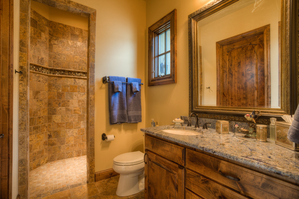Bathroom - mid-sized mediterranean 3/4 brown tile and stone tile travertine floor and brown floor bathroom idea in Austin with an undermount sink, raised-panel cabinets, medium tone wood cabinets, granite countertops, a two-piece toilet and beige walls