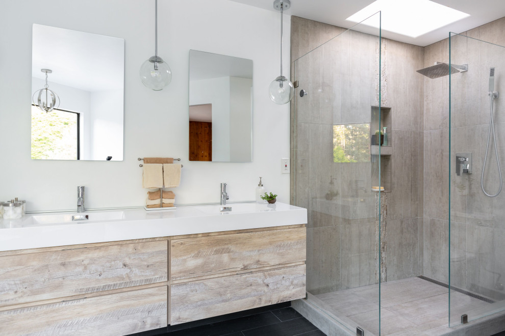 Mid-sized minimalist master gray tile and ceramic tile ceramic tile and black floor bathroom photo in Other with raised-panel cabinets, distressed cabinets, a two-piece toilet, white walls, a wall-mount sink, solid surface countertops and white countertops