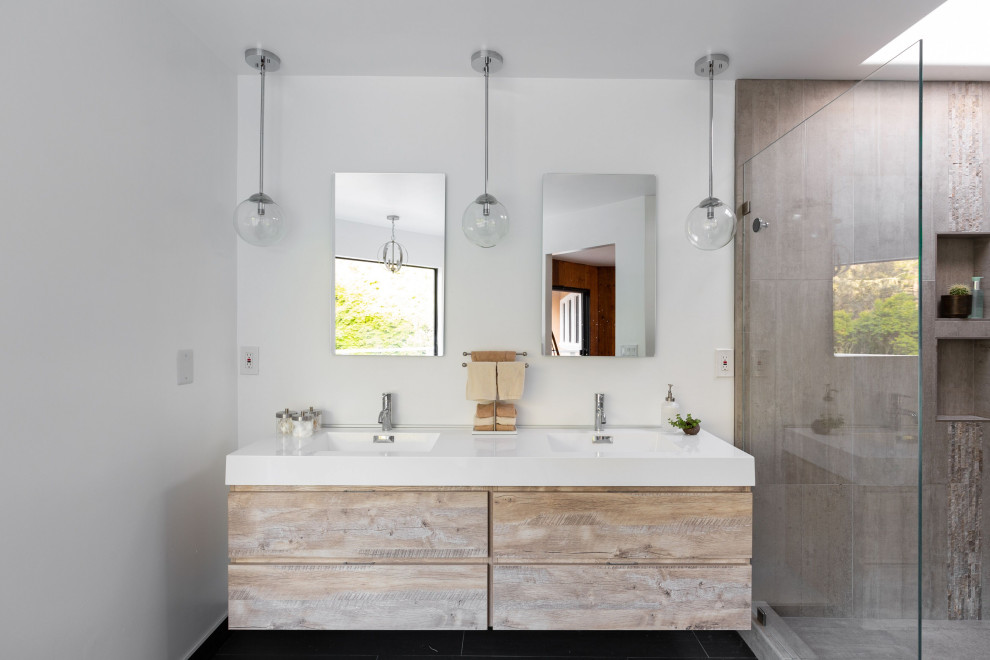 Bathroom - mid-sized modern master gray tile and ceramic tile ceramic tile and black floor bathroom idea in Other with raised-panel cabinets, distressed cabinets, a two-piece toilet, white walls, a wall-mount sink, solid surface countertops and white countertops