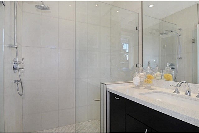 Ispirazione per una stanza da bagno minimal con ante lisce, ante nere, doccia alcova, pareti bianche, lavabo sottopiano e top in granito