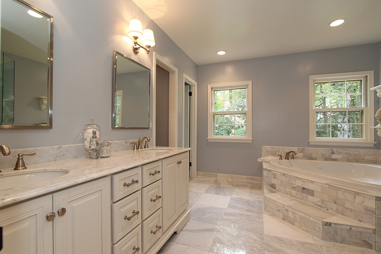 Design ideas for a classic bathroom in DC Metro with a submerged sink, recessed-panel cabinets, white cabinets, marble worktops, a built-in bath, a corner shower, a two-piece toilet, white tiles and stone tiles.