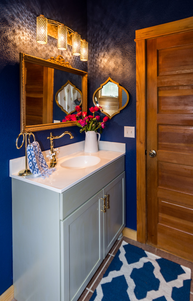 Idées déco pour une salle de bain classique de taille moyenne avec un placard à porte shaker, des portes de placard grises, WC à poser, un mur bleu, un lavabo intégré et un plan de toilette en marbre.