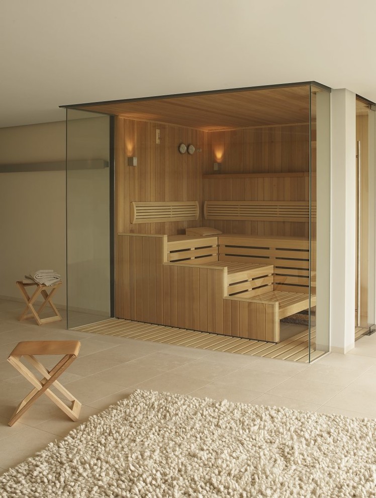 Immagine di una grande sauna moderna con pareti beige, pavimento in travertino e pavimento beige