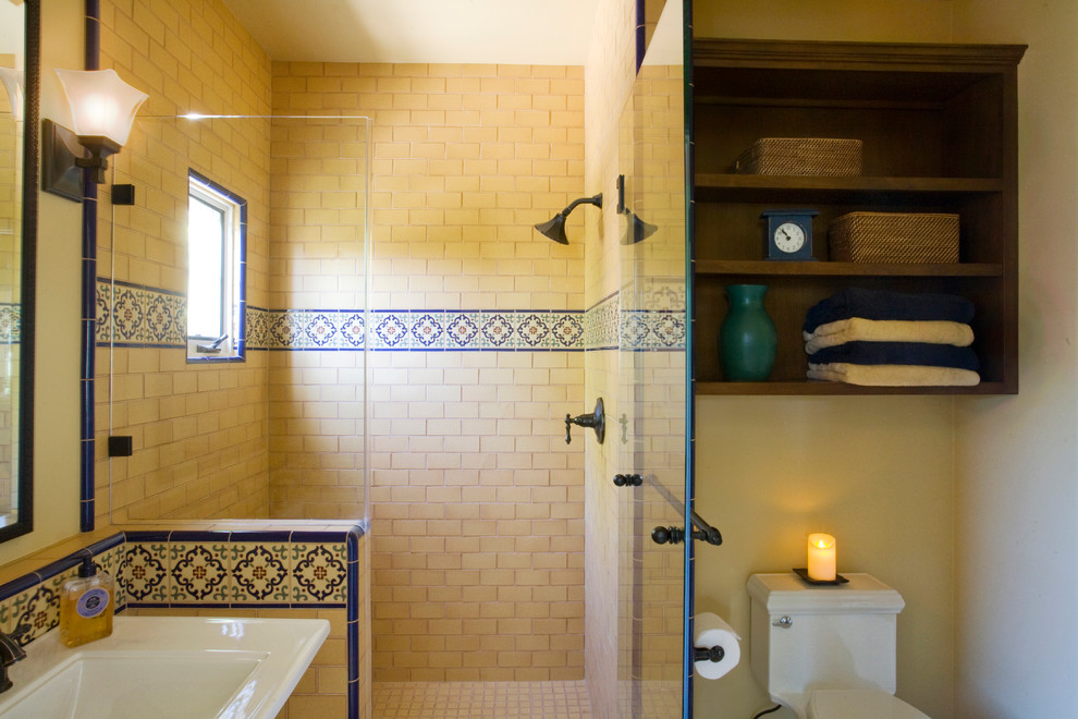 Idéer för mellanstora medelhavsstil badrum med dusch, med ett piedestal handfat, öppna hyllor, skåp i mörkt trä, en hörndusch, en toalettstol med separat cisternkåpa, gul kakel, mosaik, beige väggar och klinkergolv i keramik