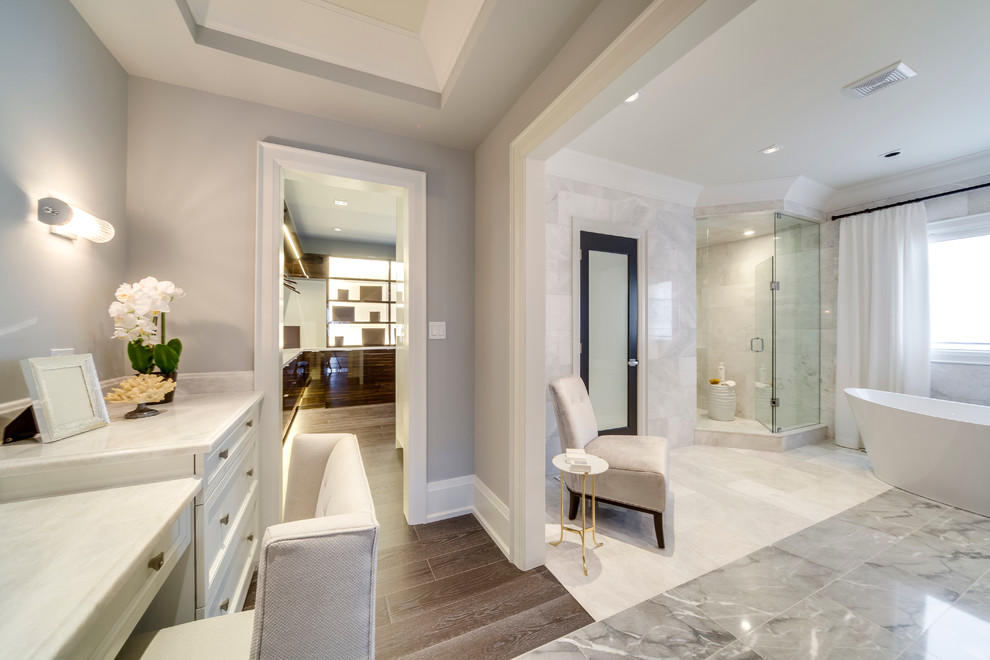 Inspiration for a traditional ensuite bathroom in Toronto with recessed-panel cabinets, white cabinets, a freestanding bath, a corner shower, white tiles, marble flooring and marble worktops.