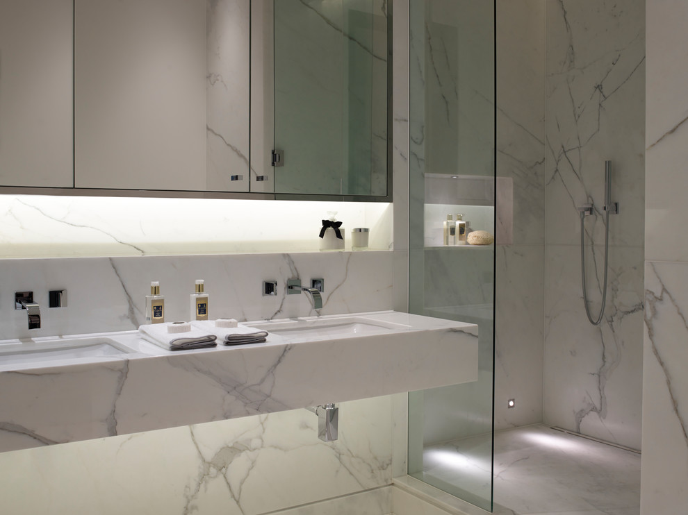 Design ideas for a large contemporary ensuite bathroom in London with white cabinets, a walk-in shower, a wall mounted toilet, white tiles, marble tiles, white walls, marble flooring, a built-in sink, marble worktops, white floors, an open shower and white worktops.