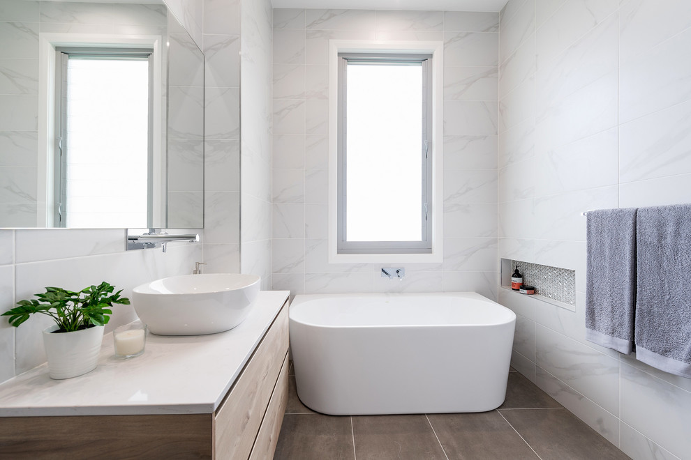 Idées déco pour une petite salle de bain contemporaine avec une baignoire indépendante, un sol en carrelage de céramique, un plan de toilette en granite et un sol beige.