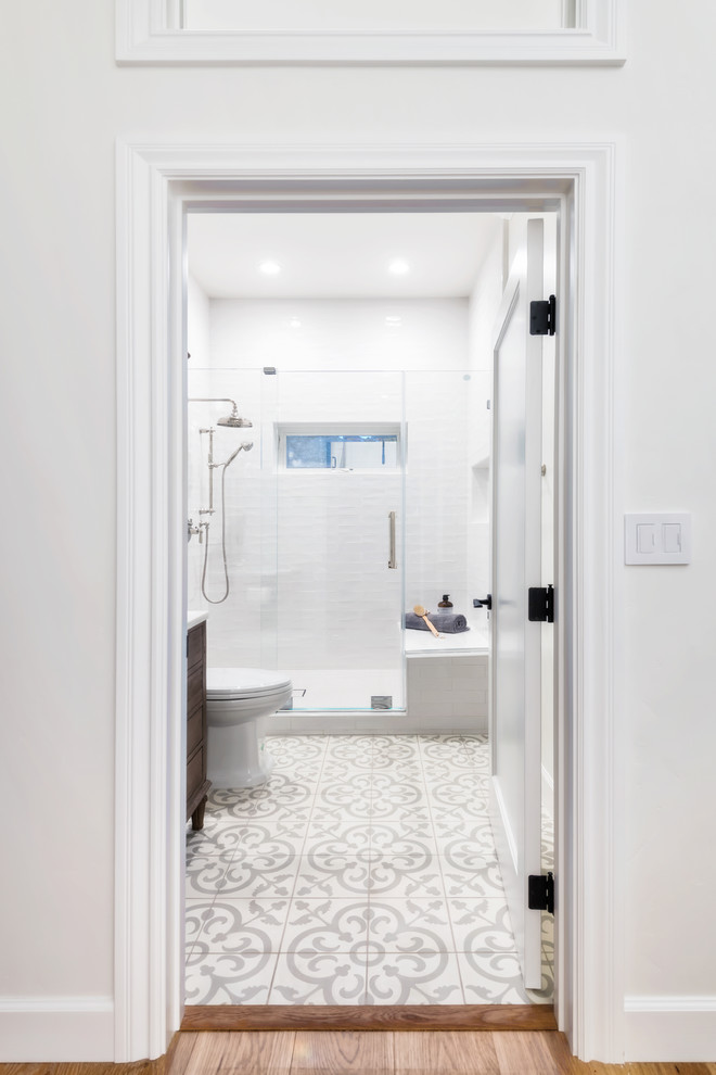 Exemple d'une salle de bain nature en bois brun de taille moyenne avec un placard à porte plane, WC à poser, un carrelage blanc, des carreaux de céramique, un mur blanc, carreaux de ciment au sol, un lavabo encastré, un plan de toilette en marbre, un sol beige, une cabine de douche à porte coulissante et un plan de toilette blanc.