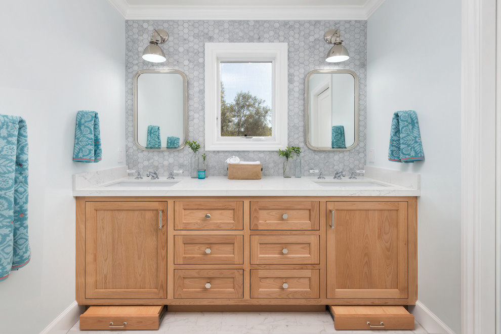 Large transitional 3/4 gray tile and marble tile porcelain tile and gray floor bathroom photo in San Francisco with light wood cabinets, a one-piece toilet, blue walls, an undermount sink, quartz countertops, a hinged shower door, white countertops and recessed-panel cabinets