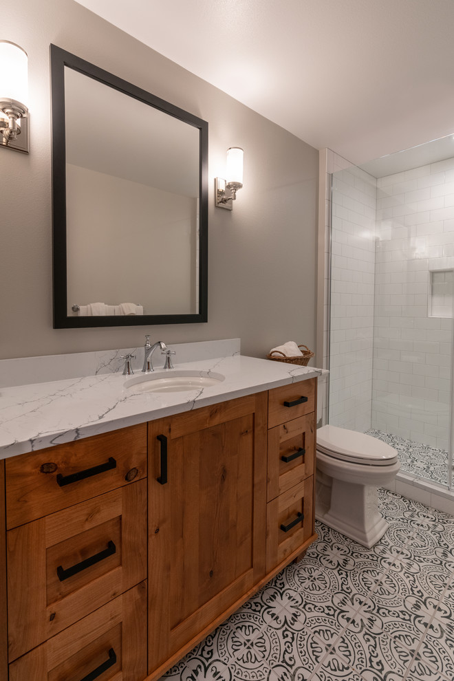 Cette photo montre une petite salle de bain chic en bois brun avec un placard à porte shaker, WC séparés, un carrelage blanc, un carrelage métro, un mur gris, un sol en carrelage de terre cuite, un lavabo encastré, un sol blanc, une cabine de douche à porte battante et un plan de toilette blanc.