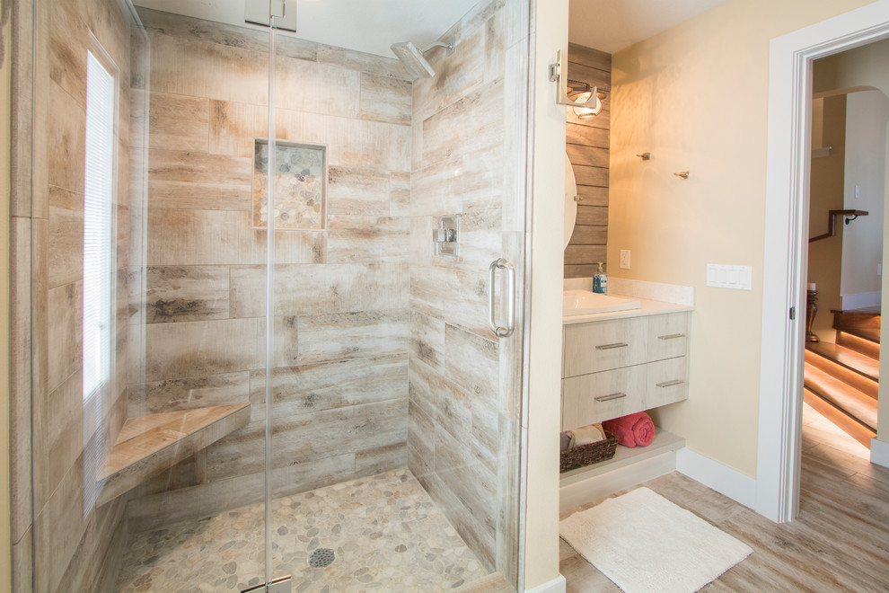 Cette photo montre une salle de bain chic en bois vieilli de taille moyenne avec un placard à porte plane, un carrelage beige, des carreaux de porcelaine, un mur jaune, un sol en carrelage de porcelaine et un plan de toilette en quartz modifié.