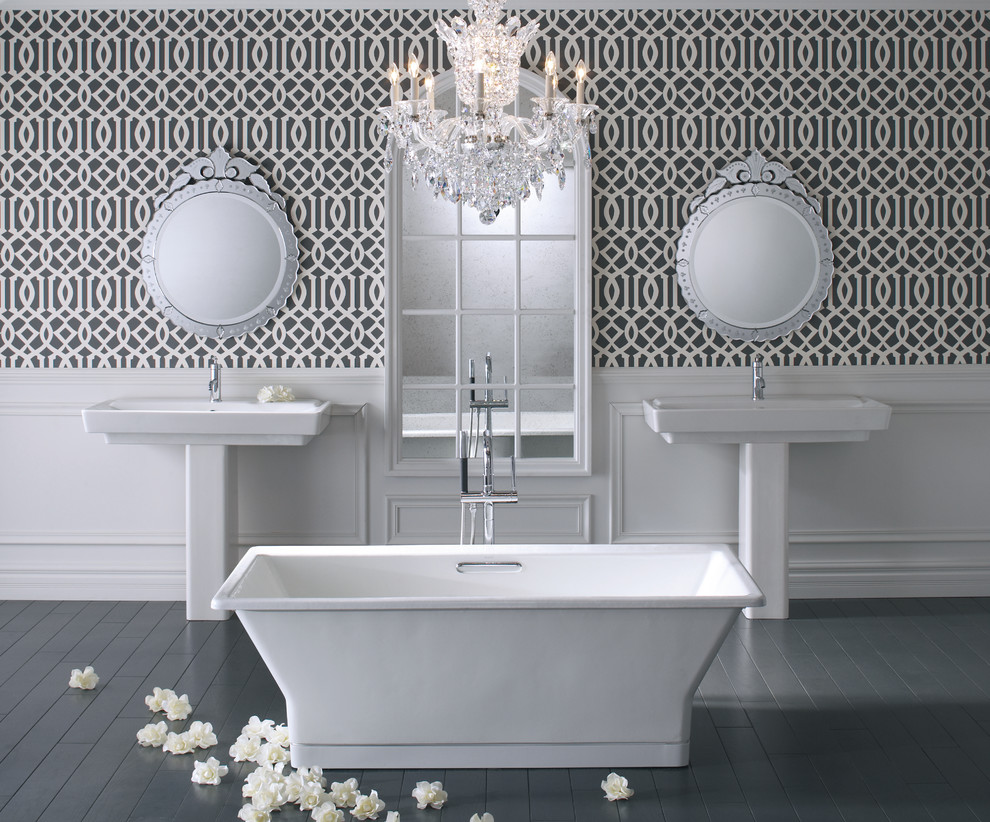 Klassisk inredning av ett stort en-suite badrum, med ett fristående badkar, ett piedestal handfat, grå väggar och mörkt trägolv