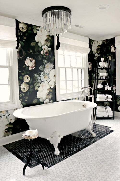 Idées déco pour une salle de bain principale classique avec des portes de placard blanches, une baignoire indépendante, un mur noir, un sol en marbre, un plan de toilette en marbre et un plan de toilette blanc.