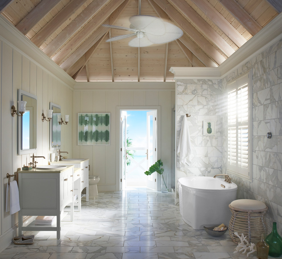 Bild på ett funkis en-suite badrum, med skåp i shakerstil, vita skåp, ett fristående badkar, en dusch i en alkov, en toalettstol med separat cisternkåpa, vit kakel, stenhäll, vita väggar, marmorgolv, ett fristående handfat, marmorbänkskiva, grått golv och dusch med gångjärnsdörr
