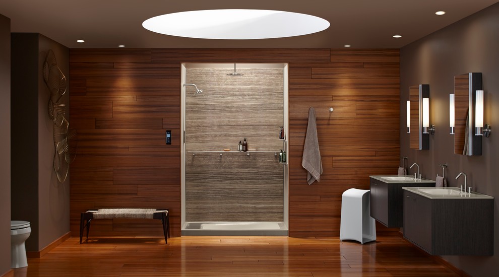 Стильный дизайн: большая главная ванная комната в стиле модернизм с плоскими фасадами, темными деревянными фасадами, душевой комнатой, раздельным унитазом, коричневой плиткой, серой плиткой, керамогранитной плиткой, серыми стенами, полом из ламината, врезной раковиной, стеклянной столешницей, коричневым полом и открытым душем - последний тренд