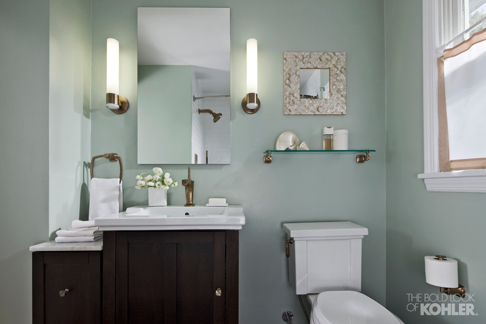 Immagine di una piccola stanza da bagno padronale classica con lavabo integrato, ante in stile shaker, ante in legno bruno, WC a due pezzi e pareti verdi