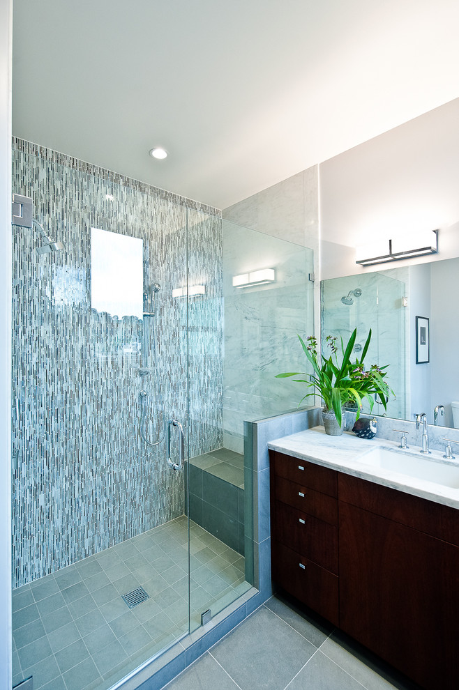 Immagine di una stanza da bagno contemporanea con lavabo sottopiano, ante lisce, ante in legno bruno, doccia alcova e piastrelle grigie