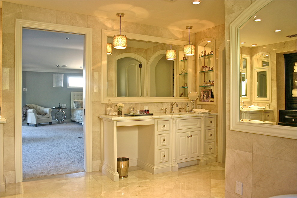 Пример оригинального дизайна: большая главная ванная комната в классическом стиле с белыми фасадами, унитазом-моноблоком, белой плиткой, мраморной плиткой, мраморным полом, врезной раковиной, мраморной столешницей, фасадами с выступающей филенкой, бежевыми стенами, бежевым полом, угловым душем, душем с распашными дверями и отдельно стоящей ванной