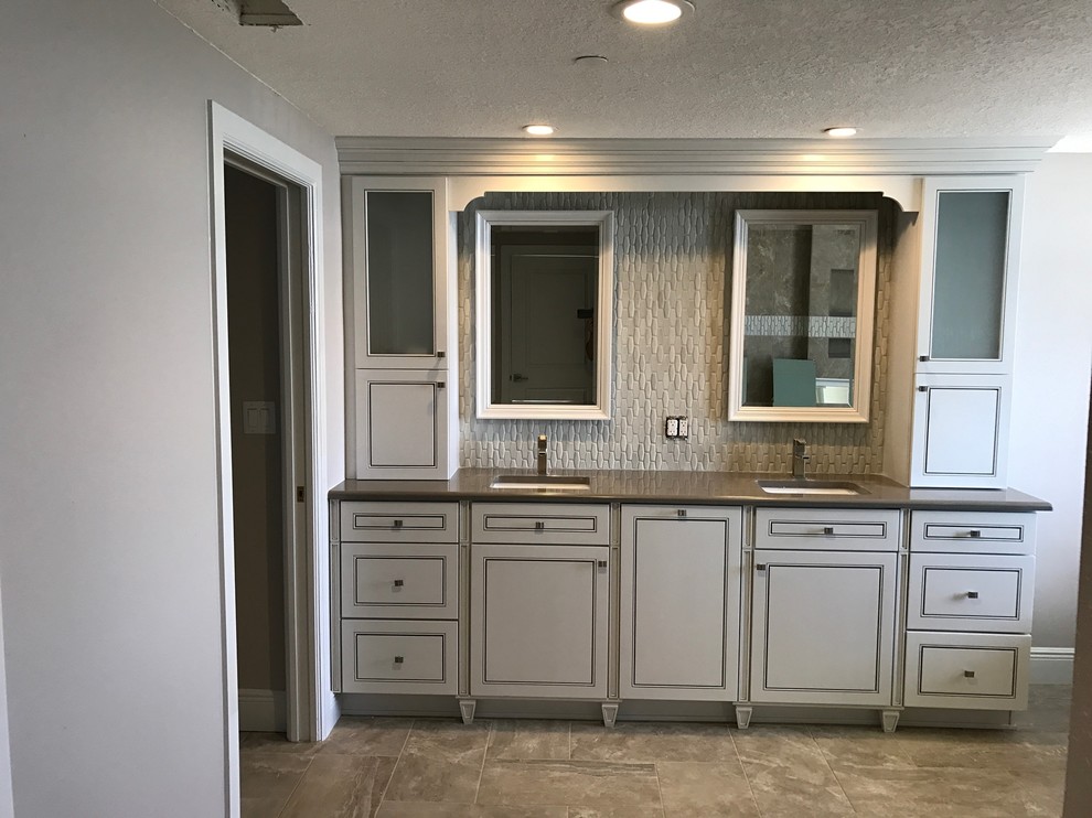 Medium sized classic ensuite bathroom in Tampa with raised-panel cabinets, white cabinets, a freestanding bath, a walk-in shower, a two-piece toilet, white tiles, ceramic tiles, beige walls, ceramic flooring, a submerged sink, engineered stone worktops, beige floors and a hinged door.