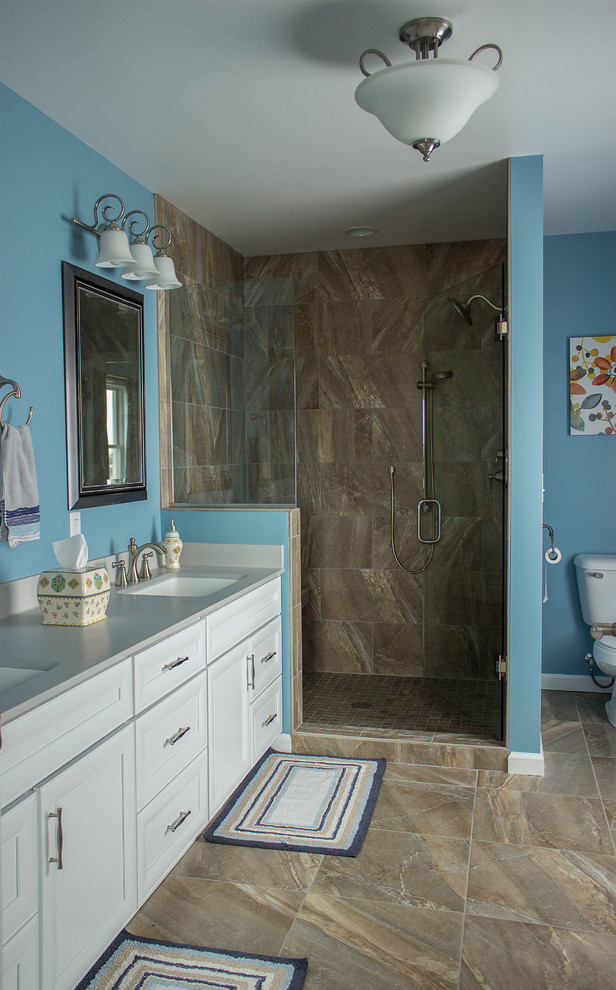 Ispirazione per una stanza da bagno padronale tradizionale di medie dimensioni con ante con riquadro incassato, ante bianche, doccia aperta, WC a due pezzi, piastrelle marroni, pareti blu, lavabo integrato e top in superficie solida