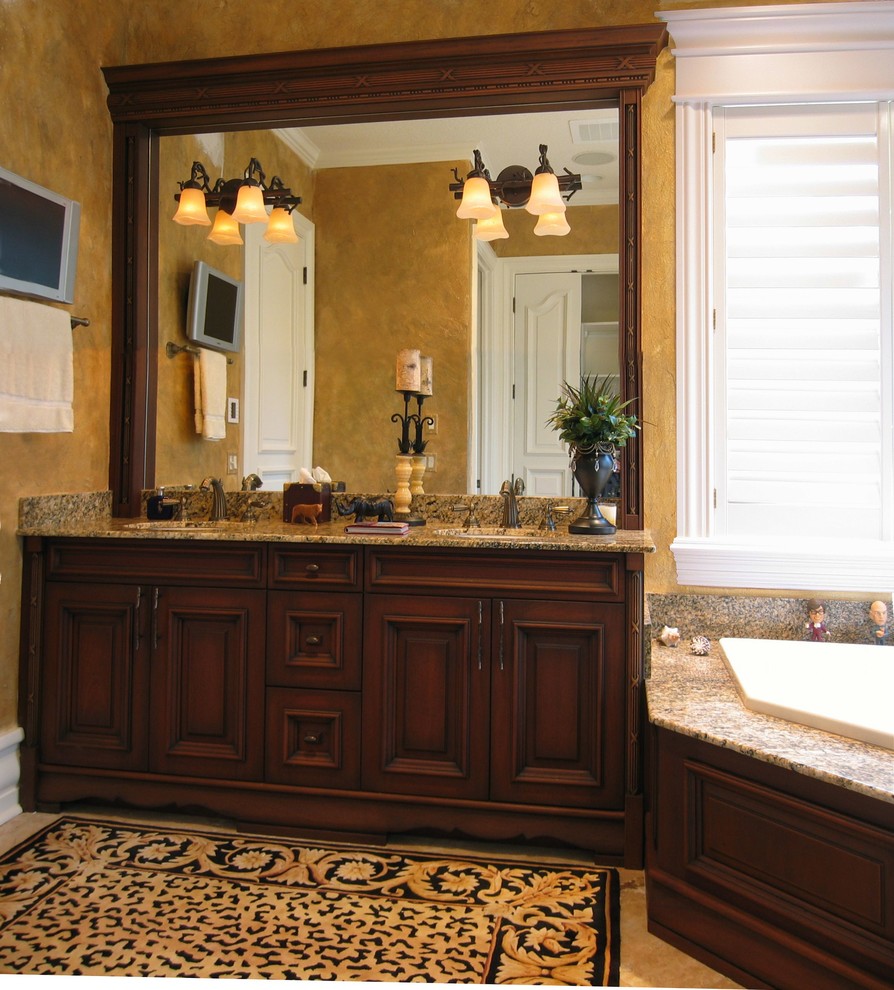 Foto di una stanza da bagno padronale mediterranea con ante con bugna sagomata, ante in legno scuro, pavimento con piastrelle in ceramica e top in granito