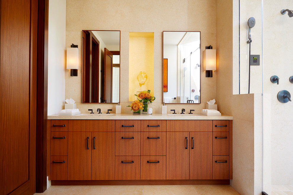 Exotisk inredning av ett badrum, med ett undermonterad handfat, släta luckor, skåp i mellenmörkt trä och beige väggar